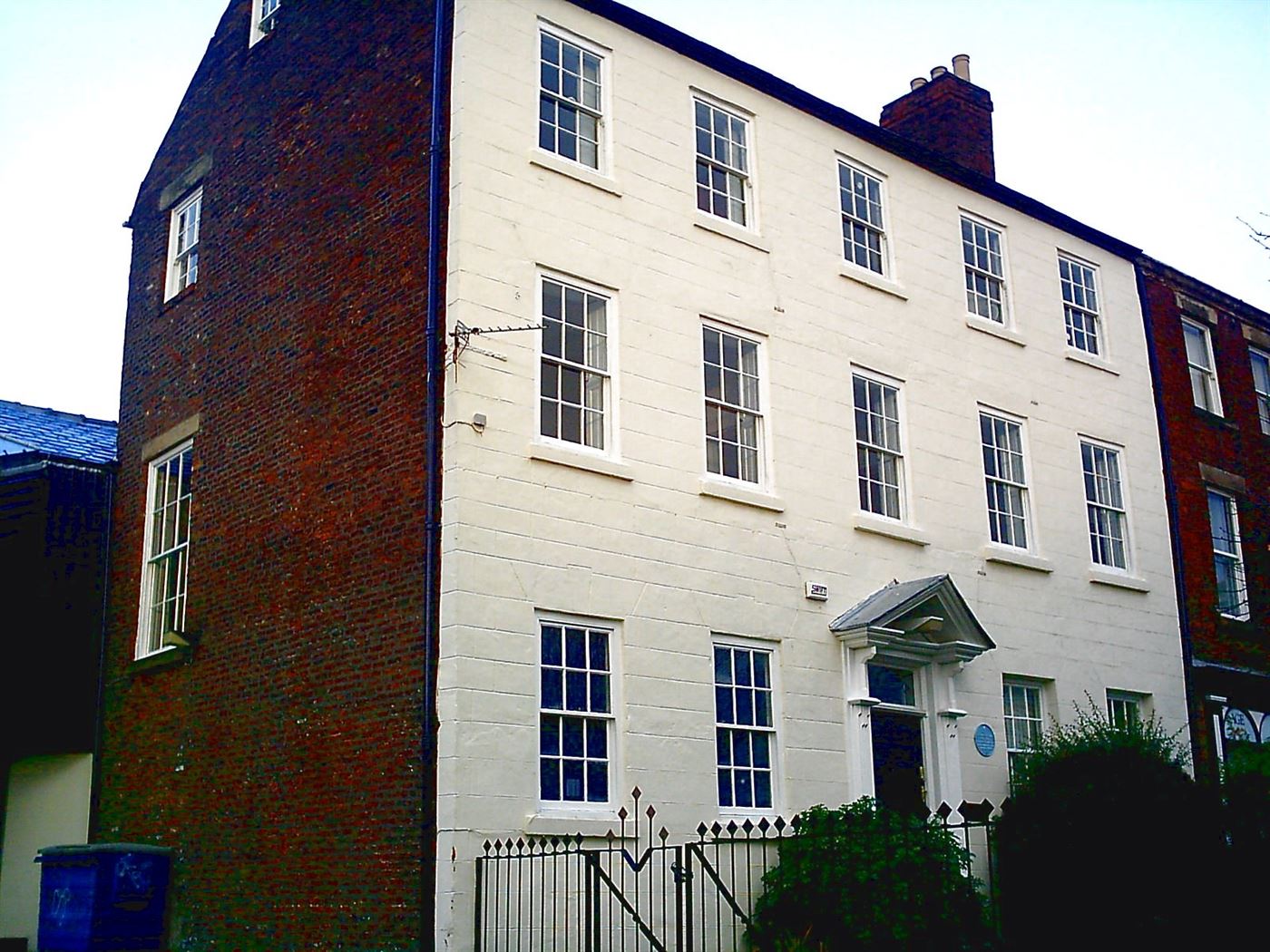 A white stucco Georgian terrace in central London, its porticos and railings standing in bright morning light